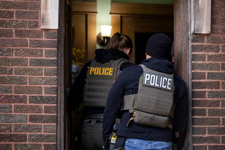 ICE agents enter an apartment building during a multiagency raid in Chicago on Jan. 26, 2025.