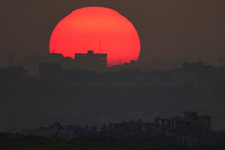 Ο ήλιος δύει πίσω από τα κτίρια που καταστράφηκαν κατά τη διάρκεια της ισραηλινής αεροπορικής και χερσαίας επίθεσης στη Λωρίδα της Γάζας, όπως φαίνεται από το νότιο Ισραήλ, Δευτέρα 10 Μαρτίου 2025. (AP Photo/Leo Correa)