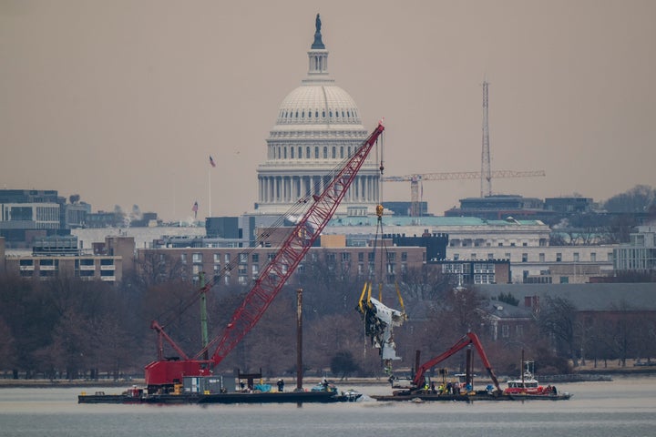 A crane is seen from Virginia as it removes airplane wreckage from the Potomac River, where American Airlines flight 5342 collided with a US military Black Hawk helicopter, near Ronald Reagan Washington National Airport, on Monday, Feb 03, 2025 in Alexandria, VA.