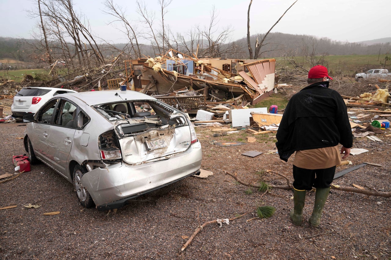 Tim Scott walks outside his destroyed home in the wake of a severe storm Saturday in Wayne County, Mo.