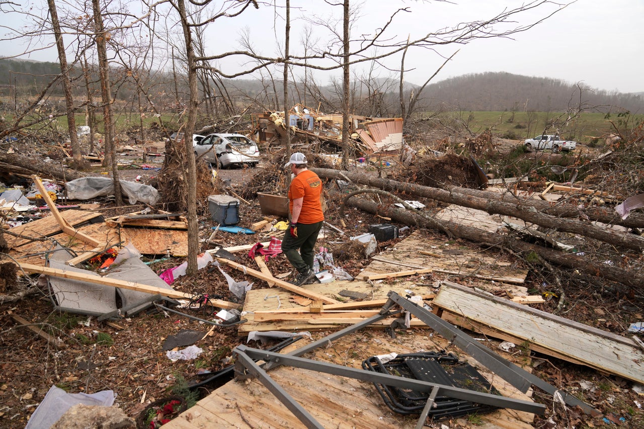 Gina Parish walks through debris left by a severe storm Saturday in Wayne County, Mo.