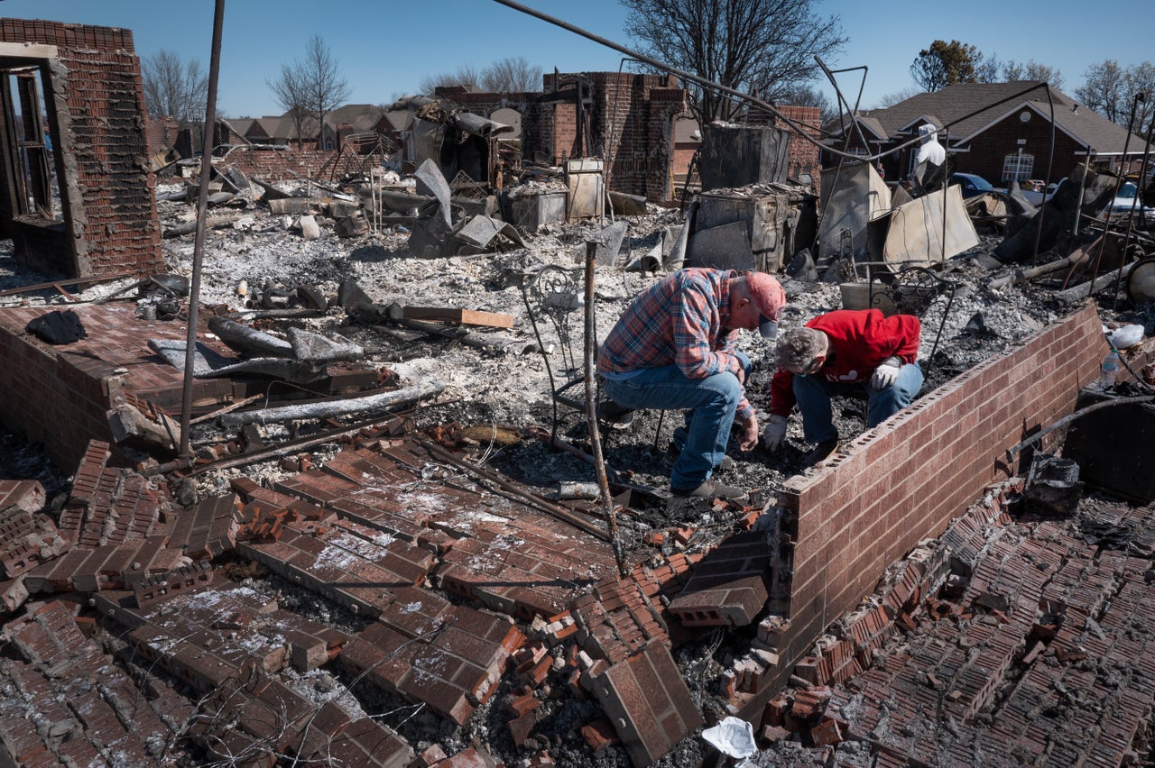 Family members help a homeowner search for salvageable possessions after their home was destroyed during Friday's wildfires in Stillwater, Oklahoma.