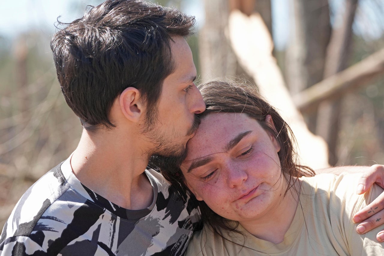 Steve Romero comforts his fiancee, Hailey Hart, on Sunday after recalling how the couple and their three dogs rode out an apparent tornado in their small automobile in Tylertown, Miss.