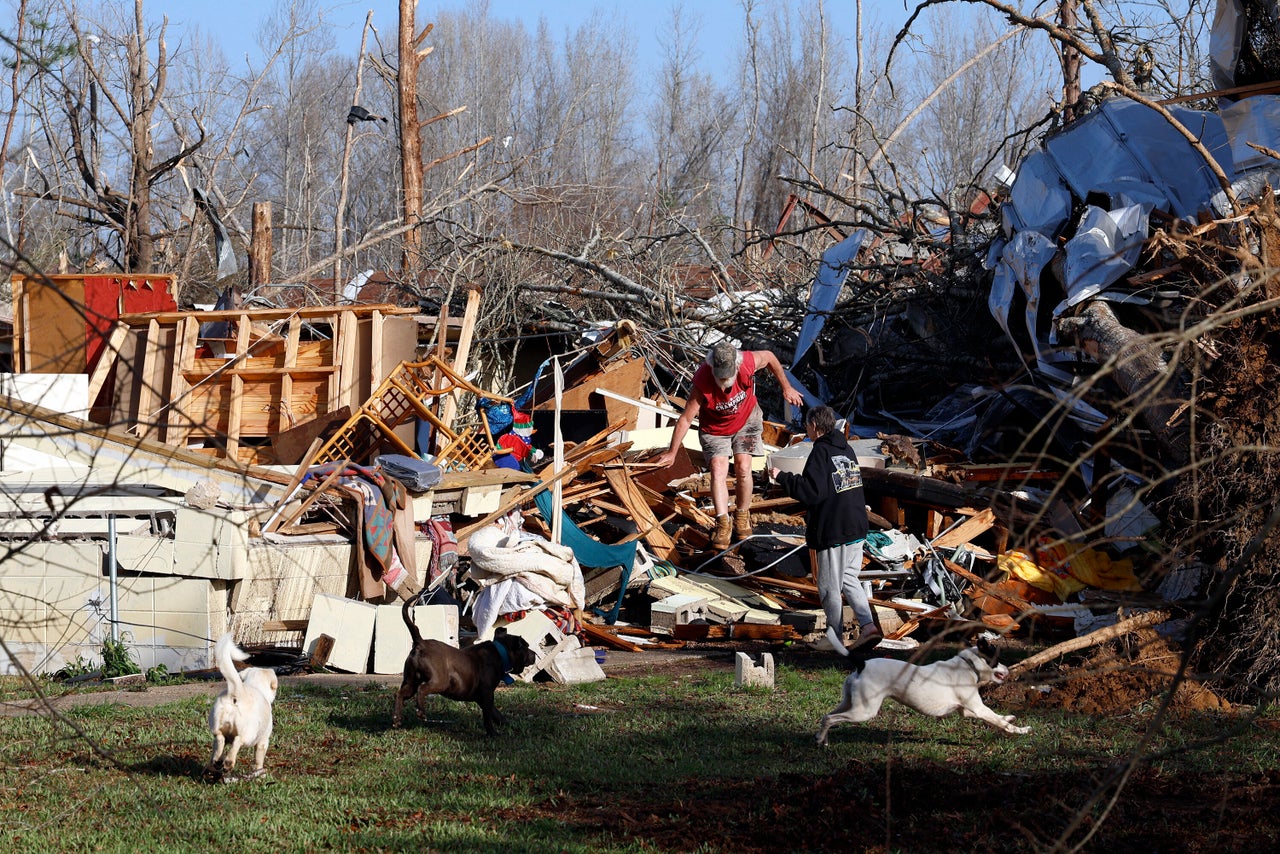 Emily and Tony Robertson look for personal belongings in the damage after a tornado passed through on Sunday in Plantersville, Ala.