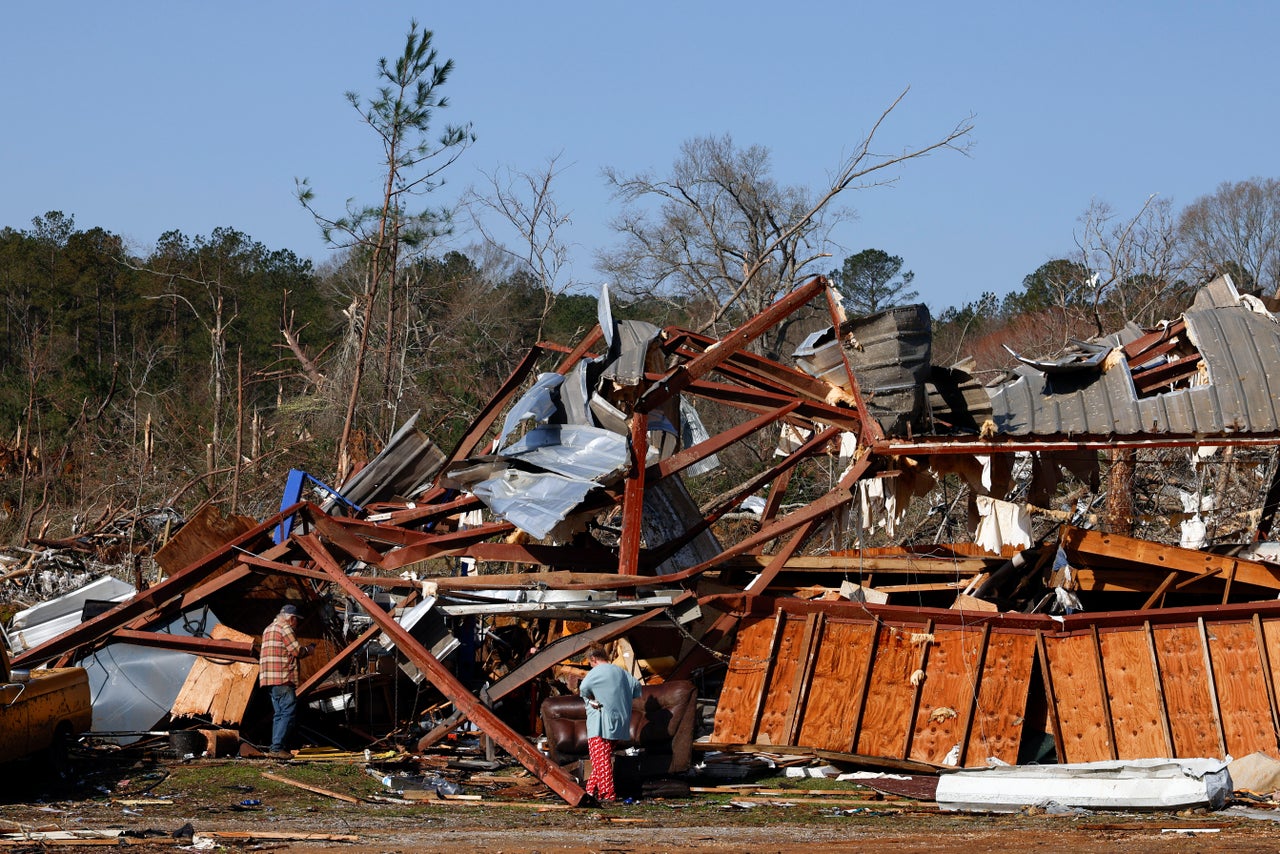 Residents look for personal belongings in the damage Sunday after a tornado passed through where two people lost their lives in Plantersville, Ala.