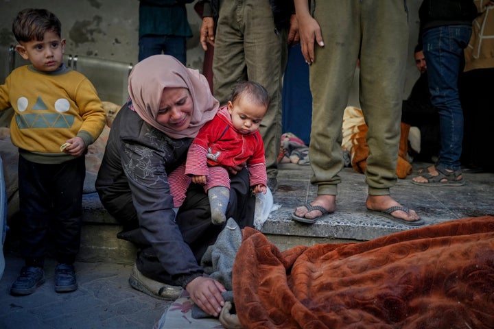 A woman mourns as she identifies a body in the Al-Ahli hospital following overnight Israeli airstrikes across the Gaza Strip, in Gaza City, on March 18, 2025.