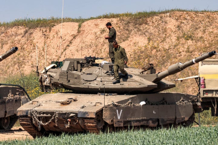 Israeli soldiers stand atop one of several Merkava battle tanks deployed in southern Israel along the northern Gaza Strip on March 18, 2025.