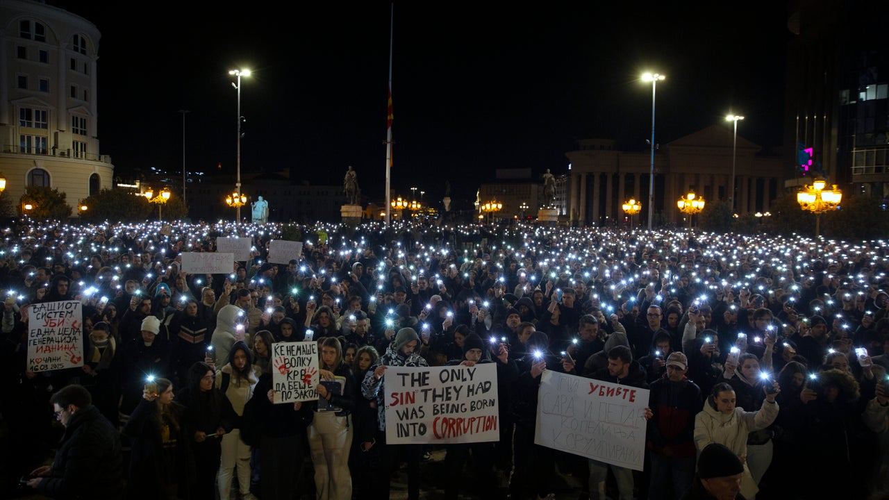 Διαδηλωτές κρατούν πλακάτ καθώς χιλιάδες άνθρωποι συγκεντρώνονται για να διαμαρτυρηθούν για τα θύματα της μεγάλης πυρκαγιάς σε νυχτερινό κέντρο στην πόλη Κοτσάνι, στα Σκόπια της Βόρειας Μακεδονίας, Τρίτη 18 Μαρτίου 2025. (AP Photo/Visar Kryeziu)