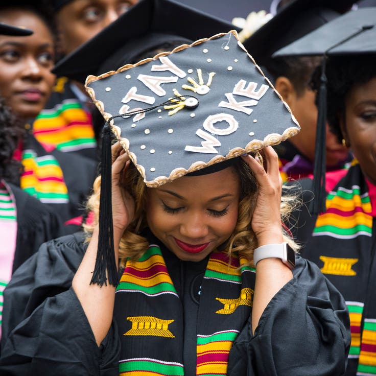A graduate adjusts her cap as she takes part in the Black Commencement at Harvard University in Cambridge, Mass., on May 23, 2017.