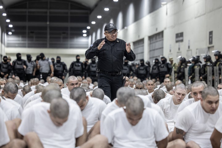 A guard gives directions on March 16 to inmates sent from the U.S. to a maximum security prison in El Salvador after they were accused of being linked to criminal organizations.