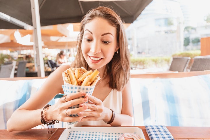 girl in street food cafe eats tasty and juicy gyros with pita. Middle Eastern cuisine concept