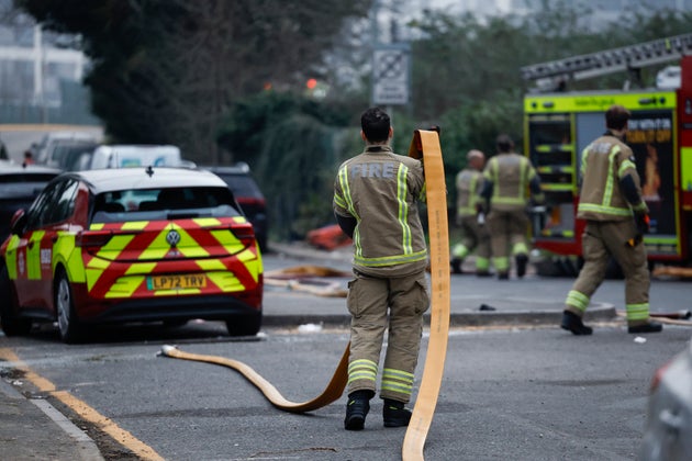 A firefighter helps putting out a fire that broke out at a substation supplying power to Heathrow Airport in Hayes, west London on March 21, 2025. 