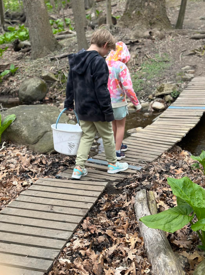 E. and his sister heading to catch frogs at a pond in the woods.