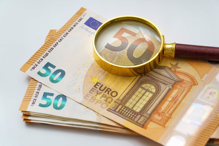 Golden magnifying glass on 50 Euro banknotes