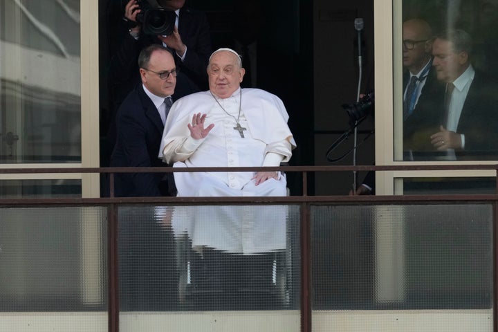 Pope Francis waves as he appears at a window of the Agostino Gemelli Polyclinic in Rome, Sunday, March 23, 2025, where he has been treated for bronchitis and bilateral pneumonia since Feb. 14. (AP Photo/Andrew Medichini)