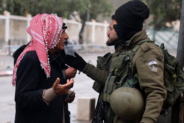 A Palestinian man talks with an Israeli border guard as he crosses an army checkpoint in Bethlehem, in the occupied West Bank, on March 21, 2025. Muslim worshippers head to the Al-Aqsa Mosque in Jerusalem's Old City for Friday prayers during the holy fasting month of Ramadan.