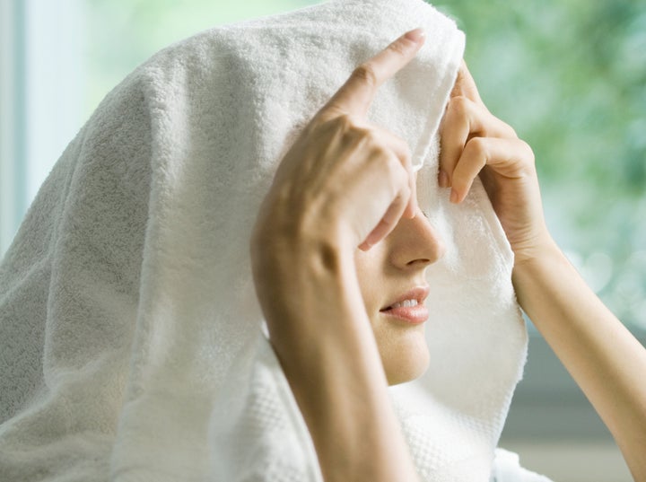 Woman holding a towel over her head