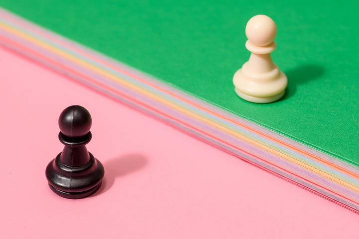 A black and a white pawn in chess facing off