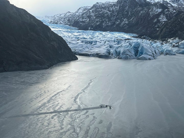 This photo provided by the Alaska National Guard shows an airplane partially submerged into the ice of Tustumena Lake at the toe of a glacier on Monday, March 24, 2025, near Soldotna, Alaska.