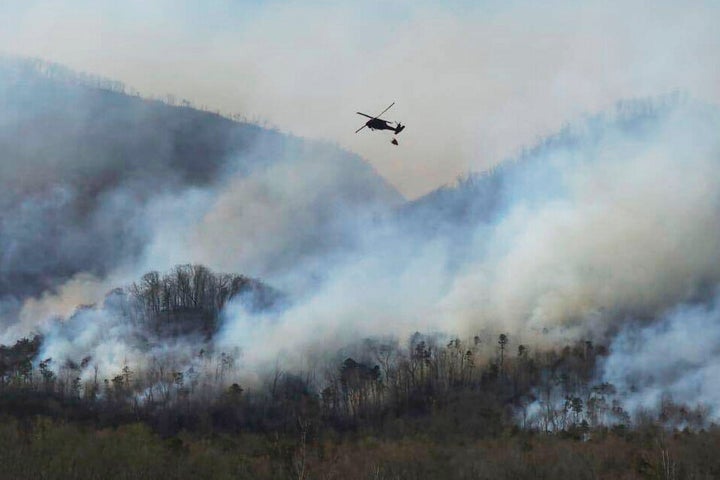 In this March 23, 2025, photo released by the U.S. National Guard shows a UH-60 Black Hawk helicopter from the 1-111th General Support Aviation Battalion, 59th Aviation Troop Command, McEntire Joint National Guard Base in Eastover executing its fire suppression mission in support of the South Carolina Forestry Commission at Persimmon Ridge Fire near Greenville, S.C.