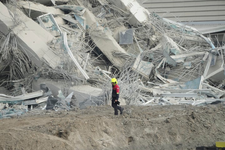 A rescuer walks past debris of a construction site for a high-rise building in Bangkok, Thailand, Saturday, March 29, 2025, during a search mission at the collapsed building after Friday's earthquake. (AP Photo/Sakchai Lalit)