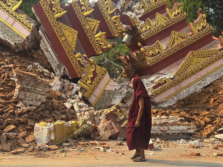 A Buddhist monk walks near a collapsed pagoda after an earthquake in Mandalay, central Myanmar, Sunday, March 30, 2025. (AP Photo/Thein Zaw)
