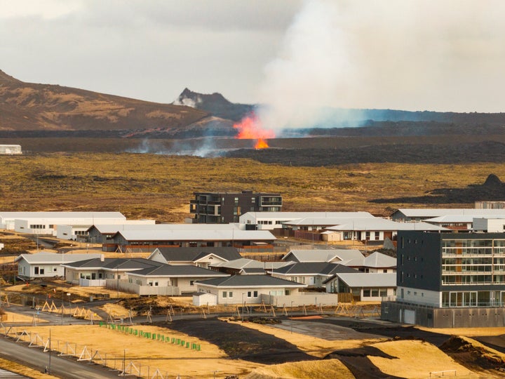 The volcanic eruption is seen in the background near the town of Grindavik.