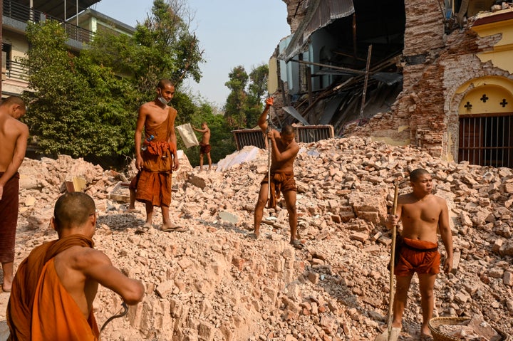 Buddhist monks stand on rubble as they clear up debris at the damaged Thahtay Kyaung Monastery in Mandalay on April 1, 2025, four days after a major earthquake struck central Myanmar. (Photo by Sai Aung MAIN/AFP via Getty Images)