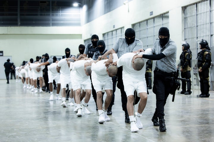 In this photo provided by El Salvador's presidential press office, prison guards transfer deportees from the U.S., alleged to be Venezuelan gang members, to the Terrorism Confinement Center in Tecoluca, El Salvador, on March 16.