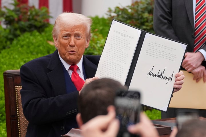 President Donald Trump holds a signed executive order during an event to announce new tariffs in the Rose Garden of the White House on Wednesday.