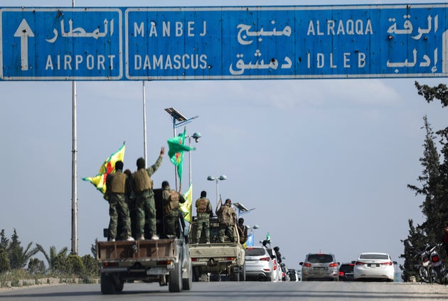 Οι υποστηριζόμενοι από τις ΗΠΑ Κούρδοι μαχητές στέκονται πάνω στα οχήματά τους, καθώς αποσύρονται από δύο γειτονιές στη βόρεια πόλη της Συρίας, το Χαλέπι, στο πλαίσιο συμφωνίας με την κεντρική κυβέρνηση της Συρίας, στο Χαλέπι της Συρίας, Παρασκευή 4 Απριλίου 2025. (AP Photo/Ghaith Alsayed)