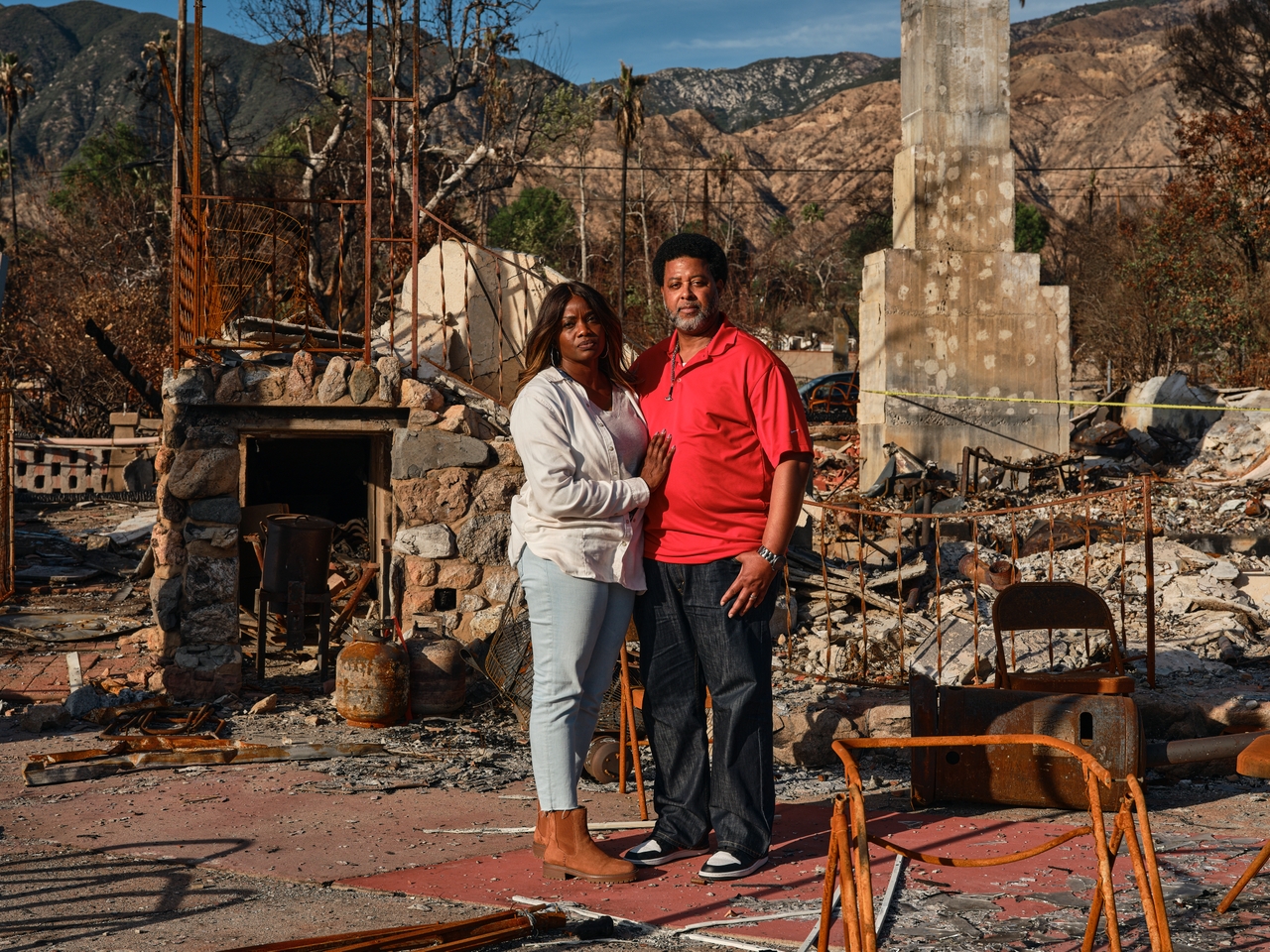 Marcus Betts, 52, and his wife, Tawana Carter, 51, pose for a portrait in the remnants of their family home that was destroyed during the Eaton fire.