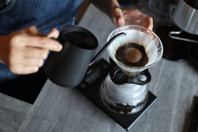 Midsection Of Person Making Coffee On Table