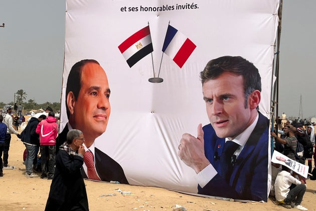 Ένας Αιγύπτιος περπατά μπροστά από ένα πανό που υποστηρίζει τον Αιγύπτιο πρόεδρο Αμπντέλ Φατάχ ελ Σίσι, αριστερά, και τον Γάλλο ομόλογό του Εμανουέλ Μακρόν, κατά τη διάρκεια της επίσκεψής τους στην πόλη Αρίς, στο βόρειο τμήμα της χερσονήσου του Σινά, περίπου 50 χιλιόμετρα δυτικά των συνόρων με τη Λωρίδα της Γάζας, Αίγυπτος, Τρίτη 8 Απριλίου 2025. (AP Photo/Mohamed Arafat)