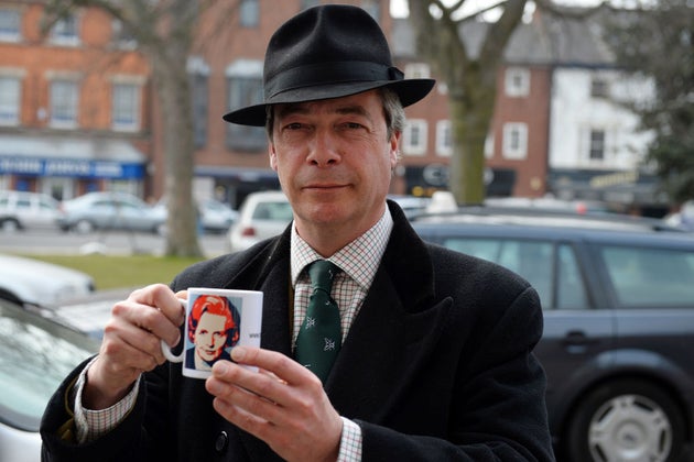 Nigel Farage shows a mug that was presented to him before signing a book of condolence for Margaret Thatcher after her death on 2013.