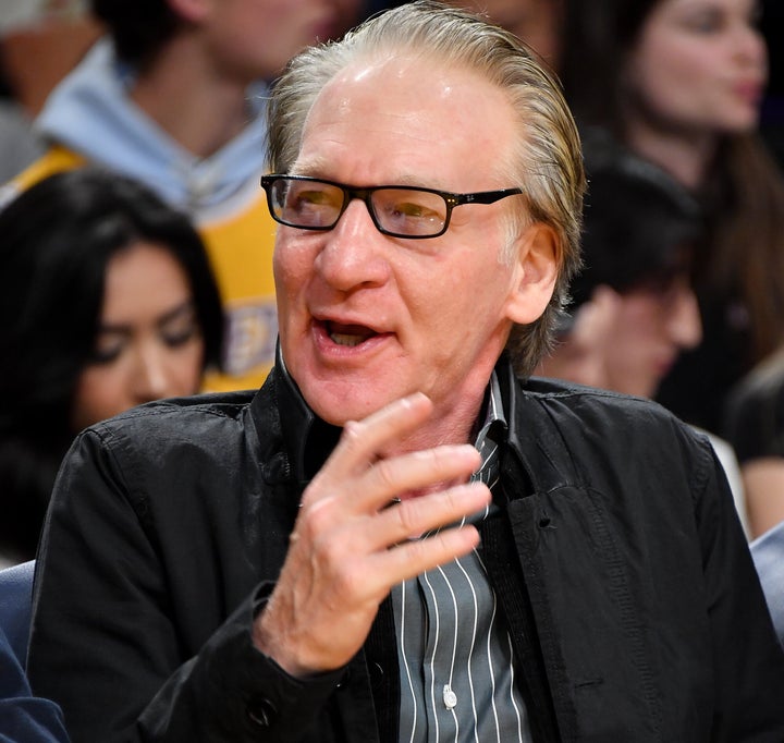 Bill Maher courtside at a Los Angeles Lakers game in 2023. He told the "2 Angry Men" podcast that people should call him a "hero" for his recent visit with President Trump.