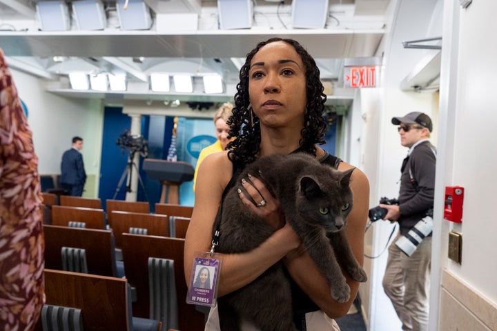 Francesca Chambers carries Sophie after reporters brought the cat back to the press area for safekeeping.