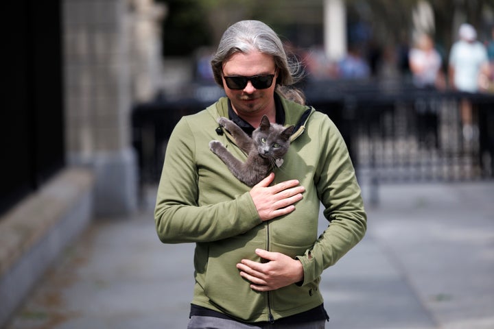 Alec Augustine carries his cat Sophie away from the White House and her short-lived press career.