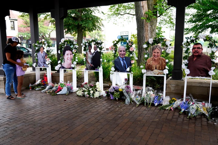 Visitors pay their respects on July 7, 2022, at altars for the seven people killed in the Fourth of July mass shooting in Highland Park, Illinois.