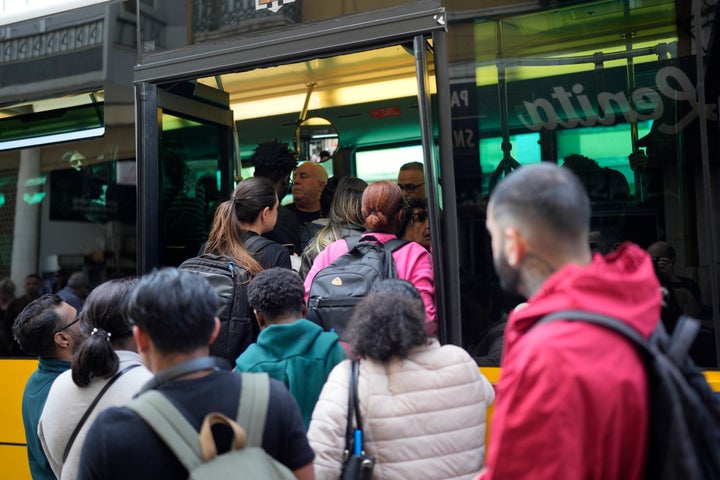 People try to board a crowded bus after the subway stopped running following a power outage in Lisbon.