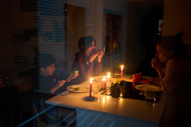 Μια οικογένεια τρώει σνακ υπό το φως των κεριών κατά τη διάρκεια ενός μπλακάουτ στη Βαρκελώνη, Ισπανία, Δευτέρα 28 Απριλίου 2025. (AP Photo/Emilio Morenatti)