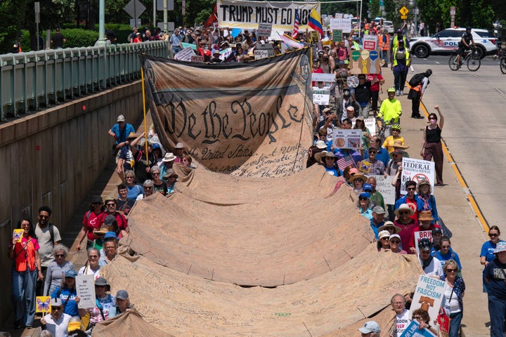 Trump Is The Goal Of Might Day Demonstrations Round The World 3 Demonstrators holding a banner march to the White House.