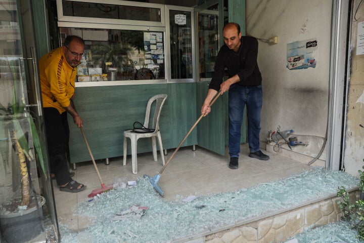 Κάτοικοι της πόλης Σανάγια αφαιρούν σπασμένα τζάμια από ένα κατάστημα που υπέστη ζημιές μετά από συγκρούσεις που ξέσπασαν μεταξύ μελών των μειονοτικών Δρούζων και των φιλοκυβερνητικών μαχητών (1 Μαΐου 2025)