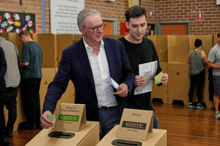 Australian Prime Minister Anthony Albanese and his son Nathan place their votes in a ballot box at a polling booth in his electorate in Sydney, Saturday, May 3, 2025. (AP Photo/Rick Rycroft)