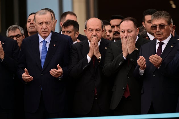 Ο Τούρκος Πρόεδρος Ρετζέπ Ταγίπ Ερντογάν, αριστερά, και ο Τουρκοκύπριος ηγέτης Ερσίν Τατάρ, στο κέντρο, προσεύχονται κατά τη διάρκεια της τελετής για τα εγκαίνια ενός νέου κυβερνητικού συγκροτήματος στα Κατεχόμενα το Σάββατο 3 Μαΐου 2025.(AP Photo/Nedim Enginsoy)