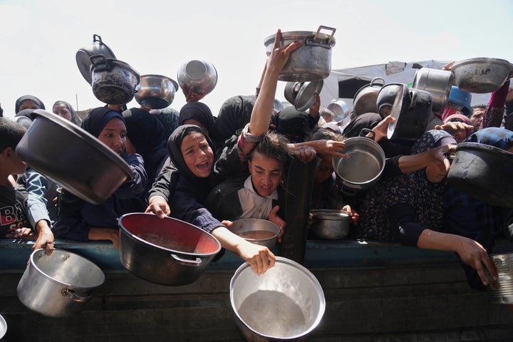 Palestinians struggle to get donated food at a community kitchen in Khan Younis, Gaza Strip, Monday, May 5, 2025. (AP Photo/Abdel Kareem Hana)