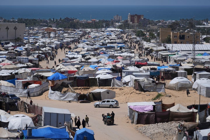 Israel Plans To Seize Gaza Underneath A New Plan, Officers Say 1 Displaced Palestinians walk through a makeshift tent camp in the Muwasi area of Khan Younis, in the Gaza Strip, on Monday, May 5, 2025. (AP Photo/Abdel Kareem Hana)