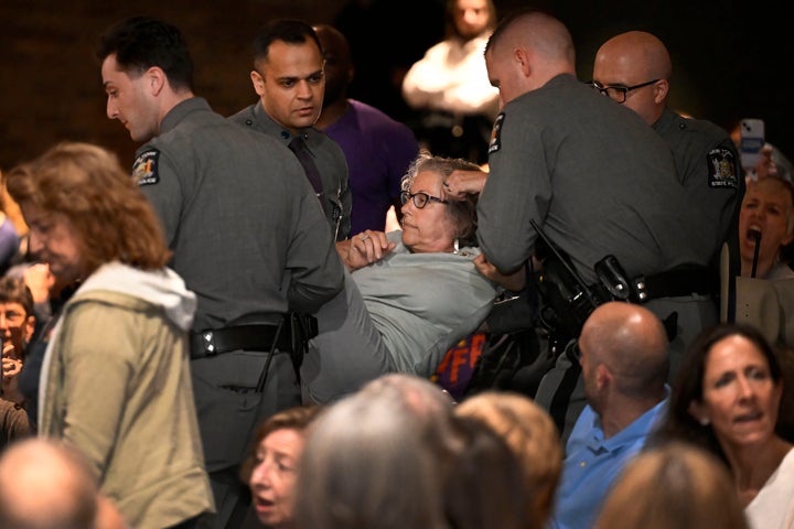 A woman is carried out by law enforcement at a town hall held by Rep. Mike Lawler (R-N.Y.) on May 4 in Somers, New York.