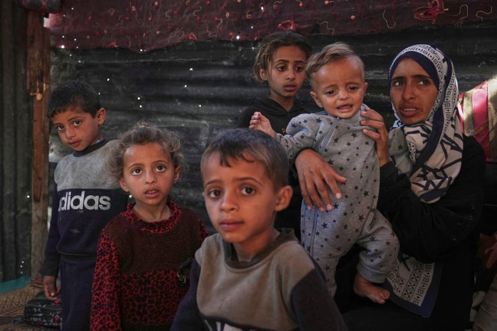 Wedad Abdelaal poses in her tent with her malnourished children at the Mawasi refugee camp in Khan Younis, Gaza, on Friday.