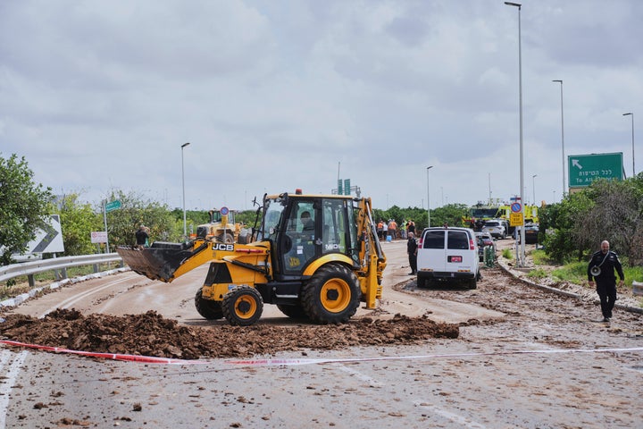 Israeli security forces clean the road from debris where the Israeli military said a projectile fired by Yemen's Houthi rebels landed in the area of Ben-Gurion International Airport near Tel Aviv, Israel, on Sunday, May 4, 2025.